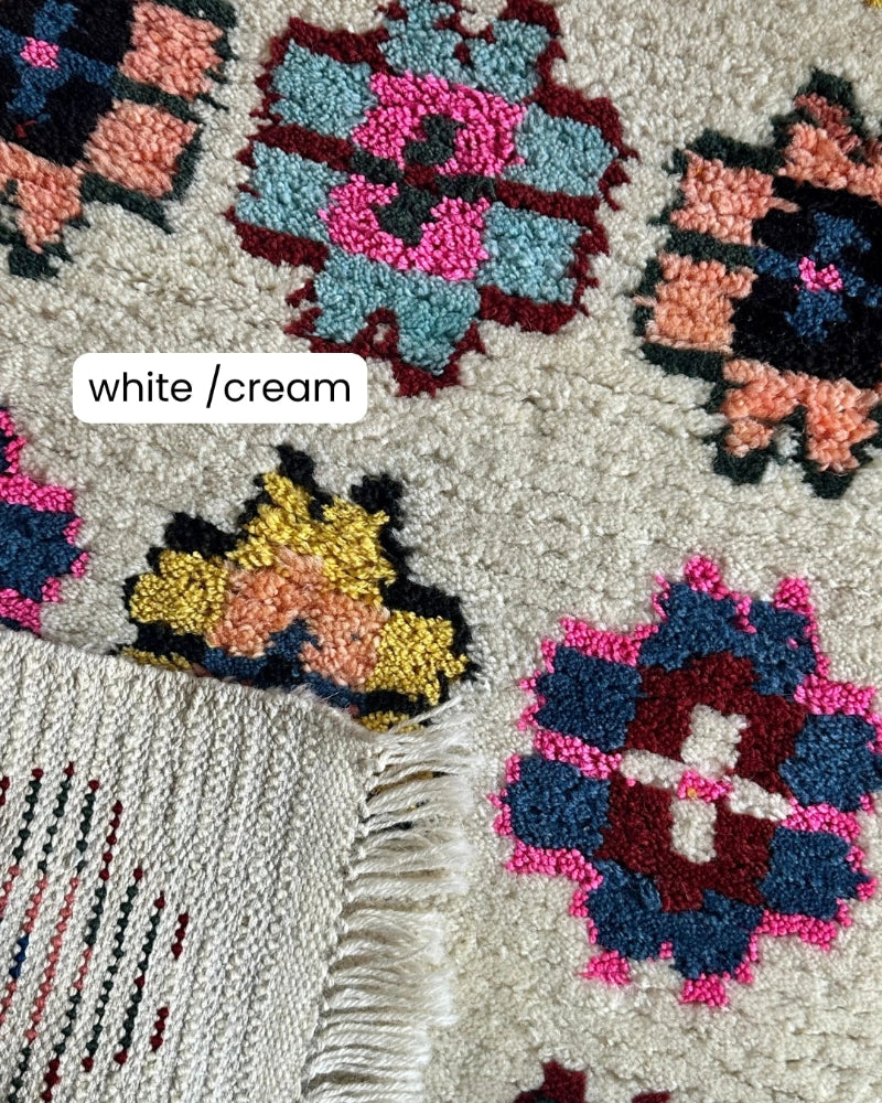 Close-up of a textured rug with colorful patterns and white/cream label.
