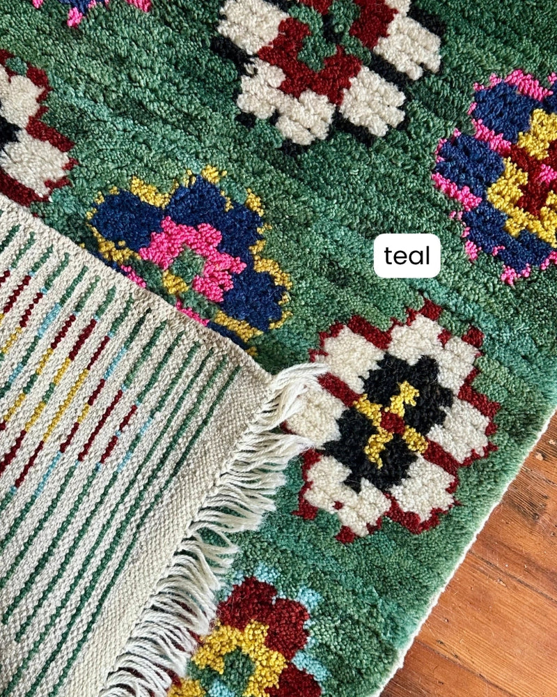 Colorful crochet rug with geometric patterns on a wooden floor.