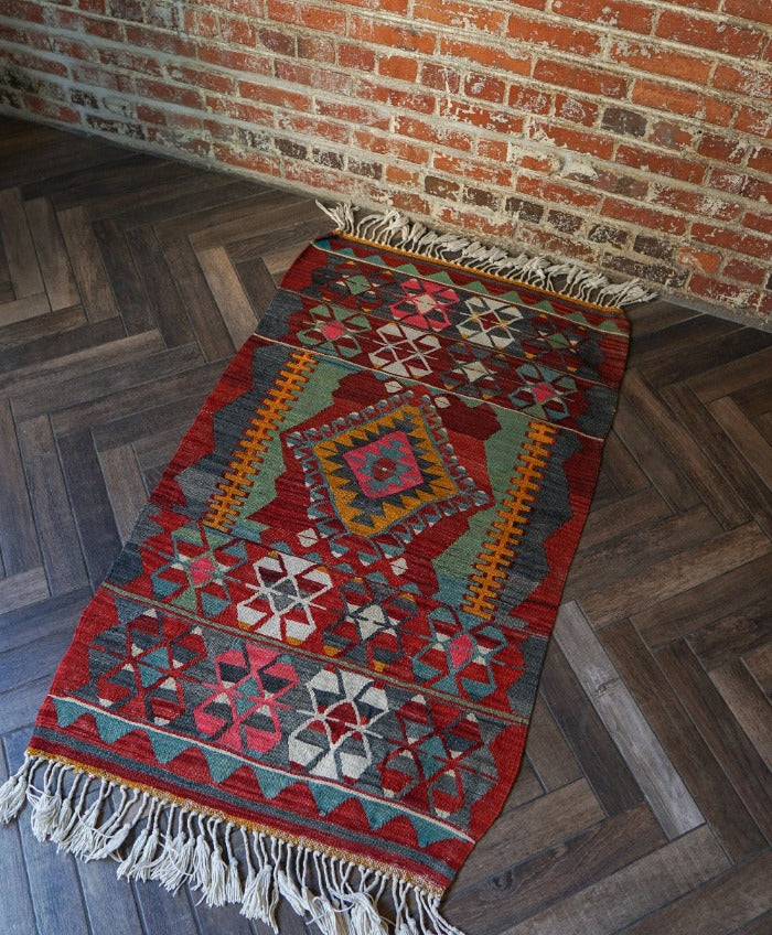 5.5 by 2.9 foot colorful Turkish area rug featuring diamond geometric patterns and bright accent colors
