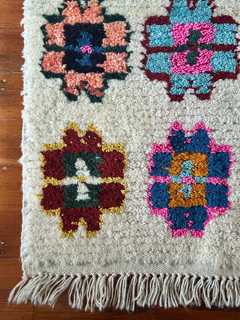 Colorful woven rug with geometric patterns on a wooden floor