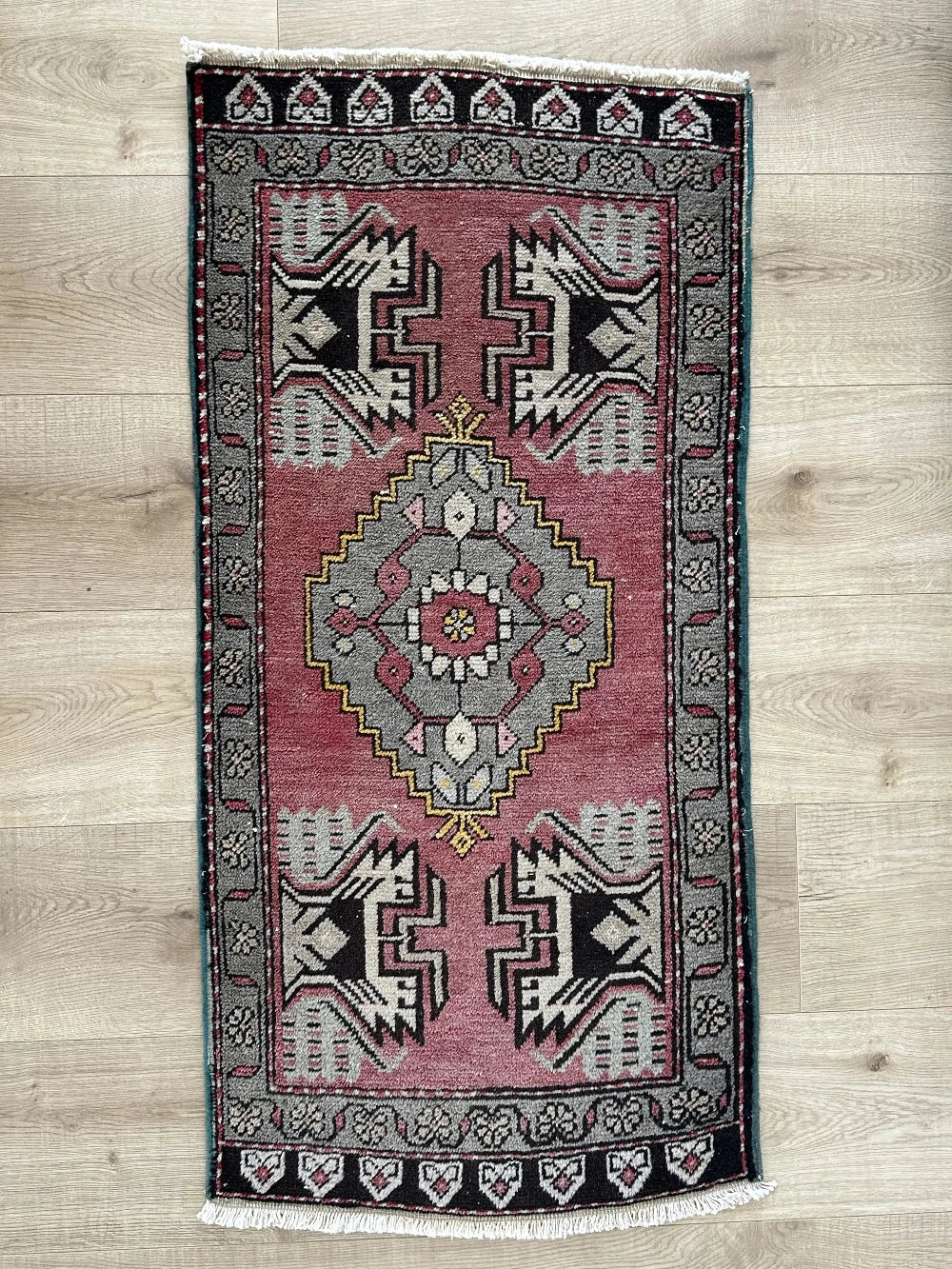 colorful mini Turkish Yastik, with a blue and mauve floral border and inner motif with geometric design in each corner