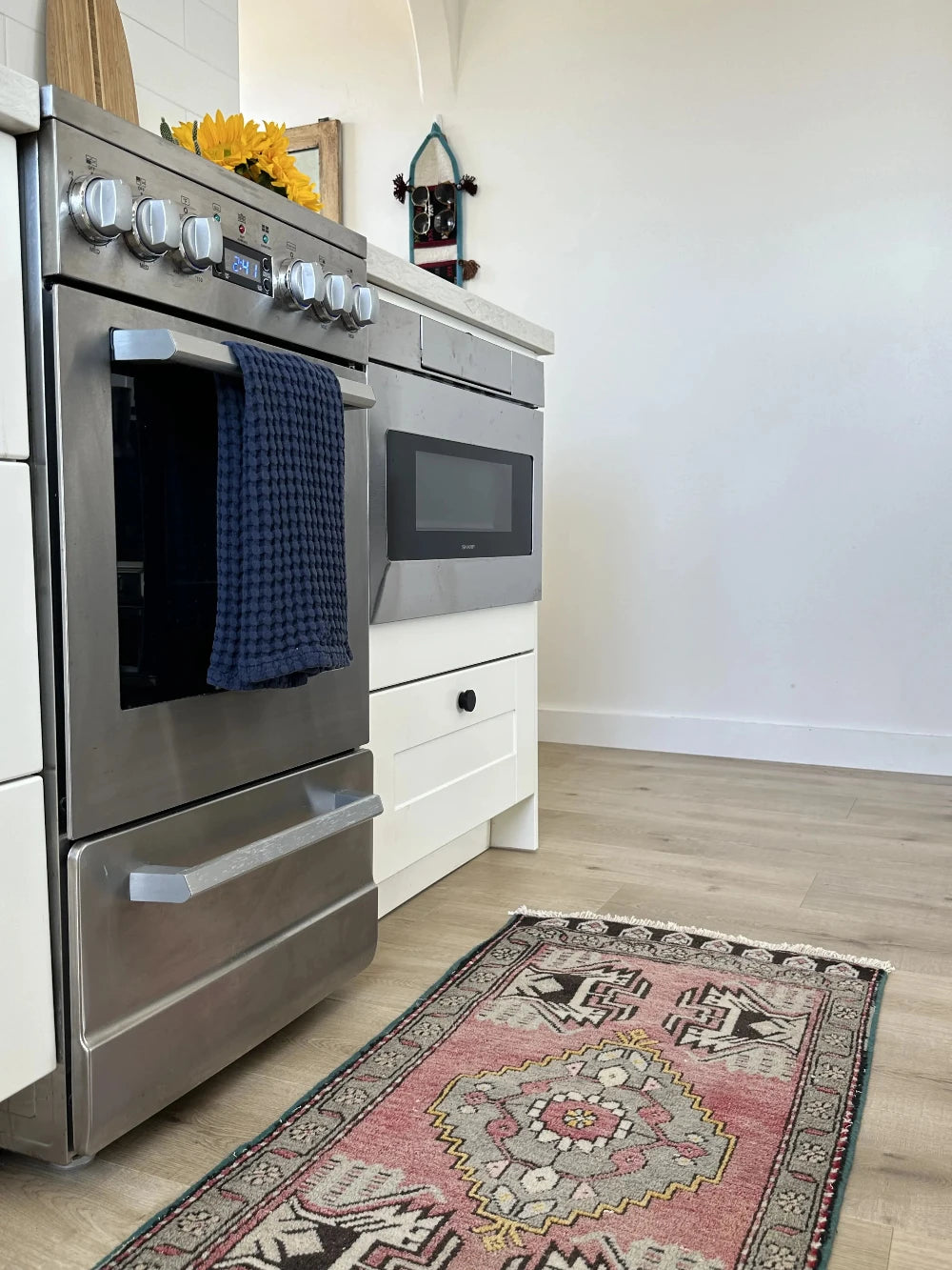 colorful mini Turkish Yastik, with a blue and mauve floral border and inner motif with geometric design in each corner