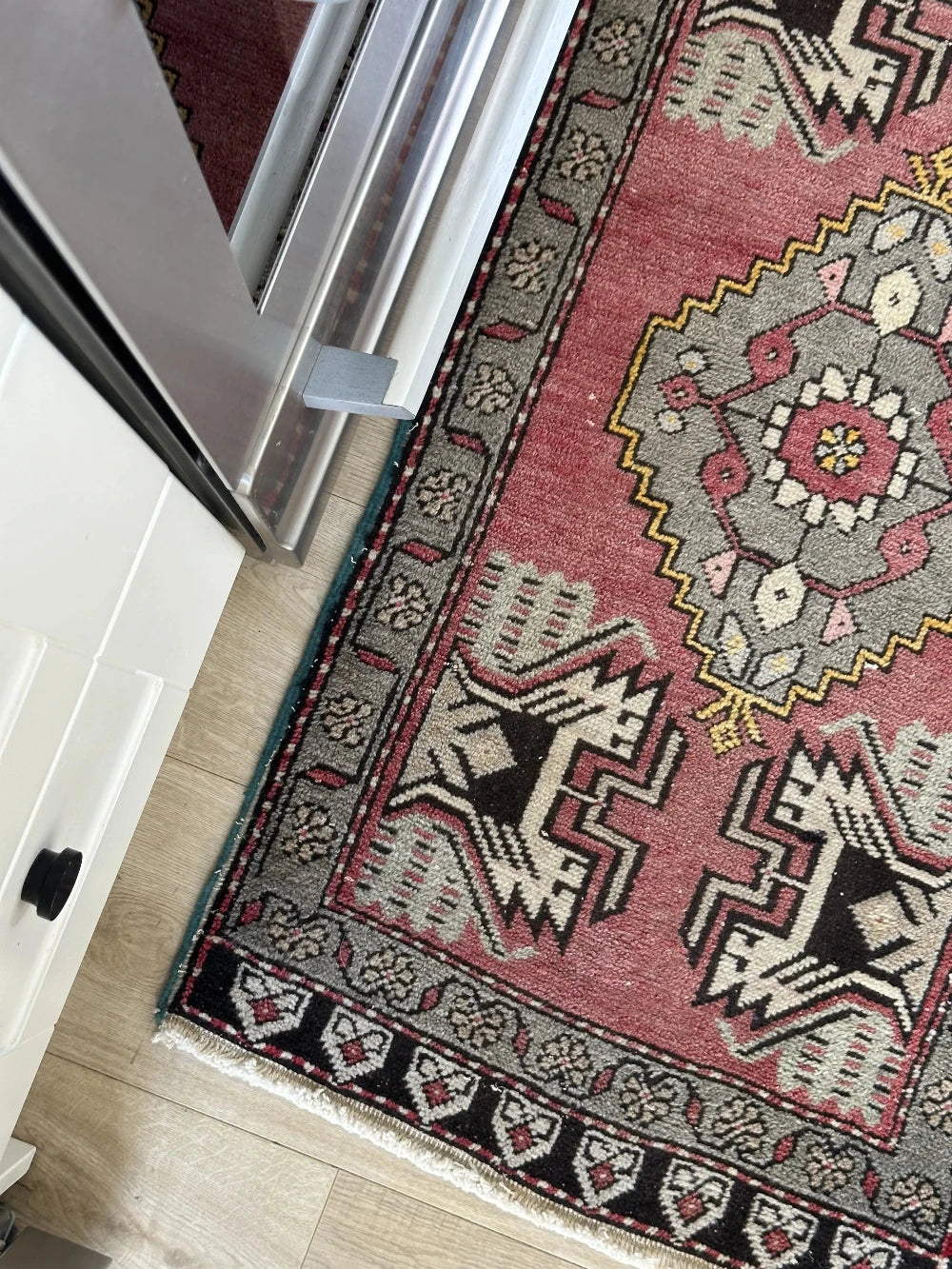 colorful mini Turkish Yastik, with a blue and mauve floral border and inner motif with geometric design in each corner