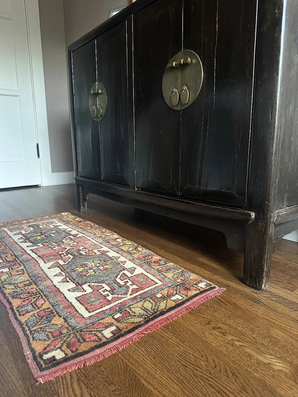 colorful mini turkish rug featuring pops of orange, green, navy and mauve and geometric patterns throughout