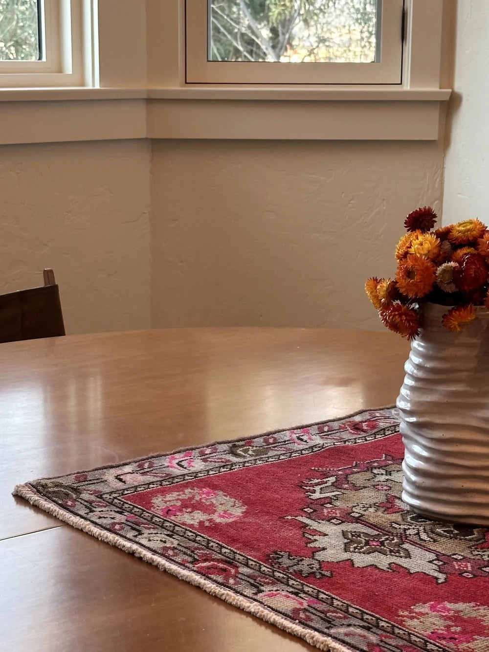 square mini red Turkish rug with a rose patterned border and large geometric medallion center