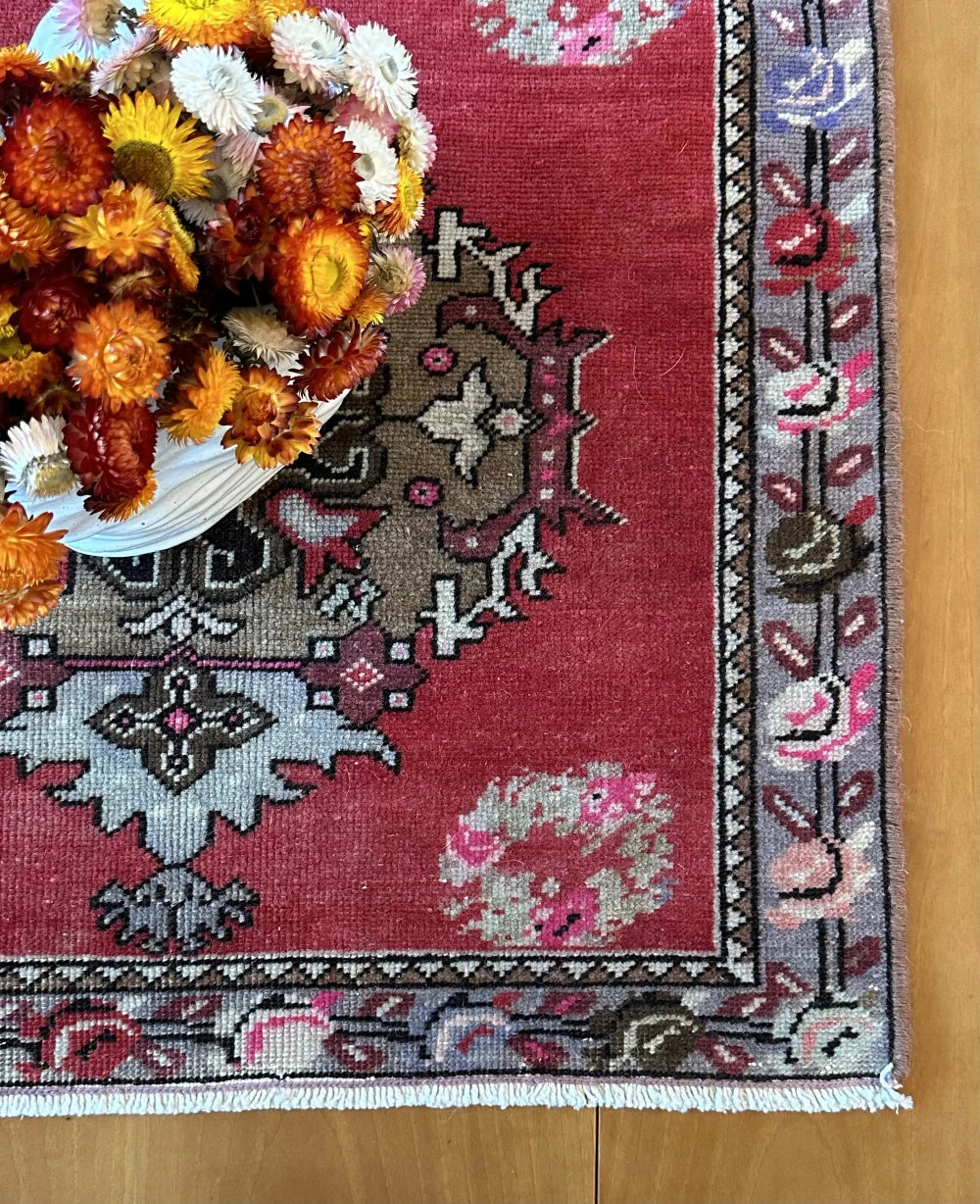 square mini red Turkish rug with a rose patterned border and large geometric medallion center