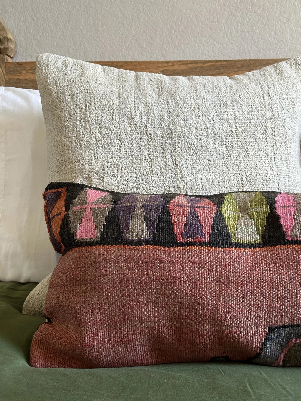 12 by 36 colorful turkish lumbar pillow featuring an all over merlot coloring and a geometric multi-colored band at the top with pops of pink, purple, green and orange