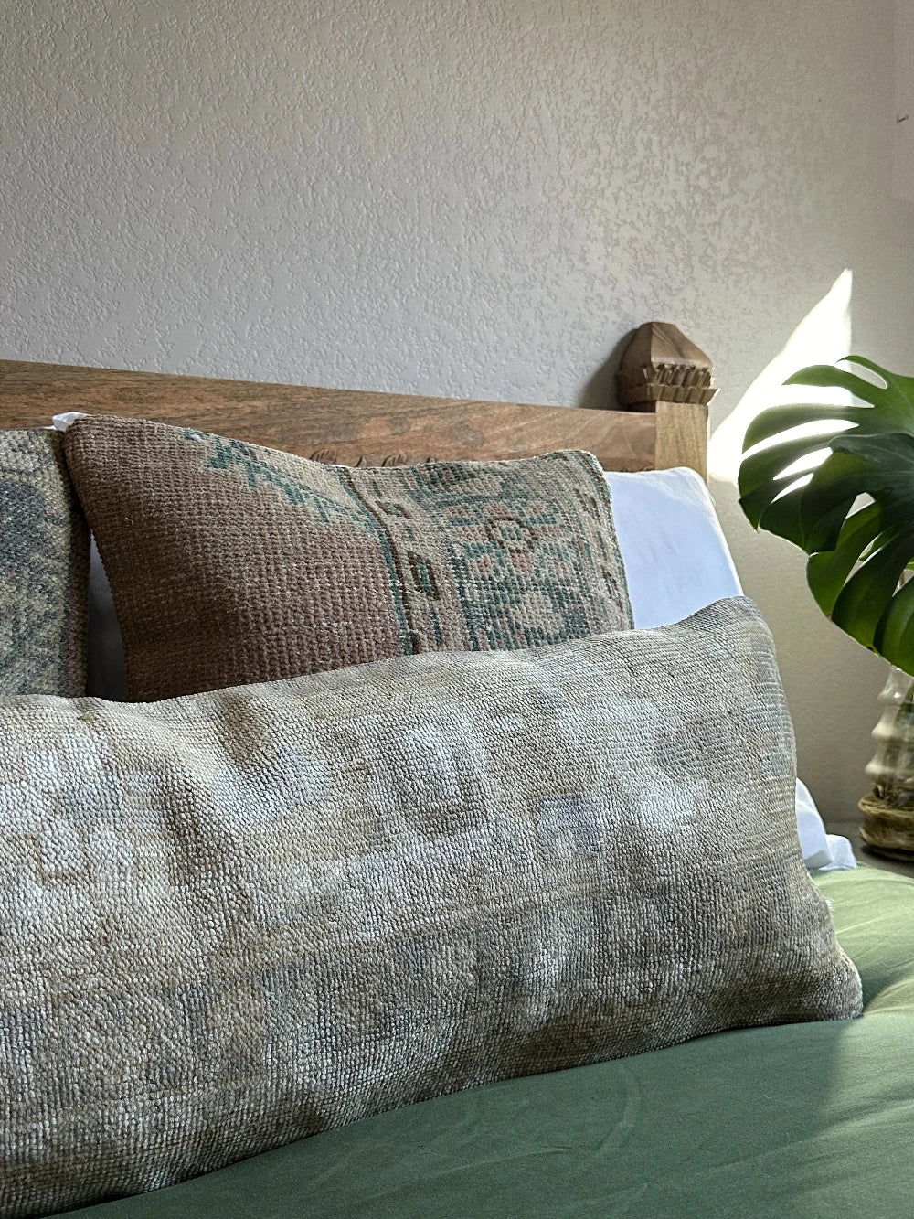 12 by 36 neutral lumbar pillow featuring a geometric design and hints of lilac, tan and sand.