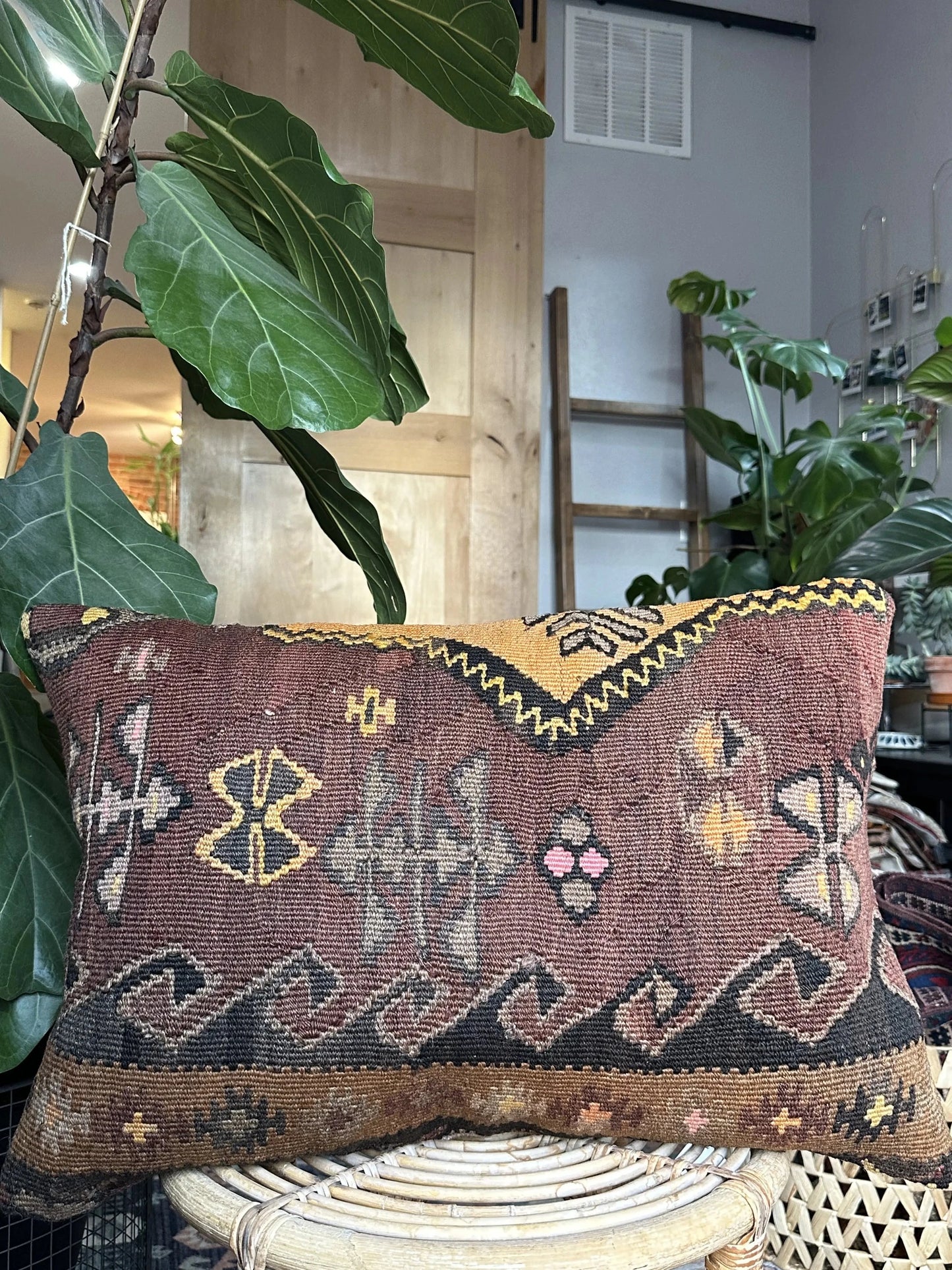 16 by 24 Turkish lumbar pillow featuring a muted color palette of browns and purples and accent colors of orange and yellow with geometric patterns throughout upcycled from a Turkish rug