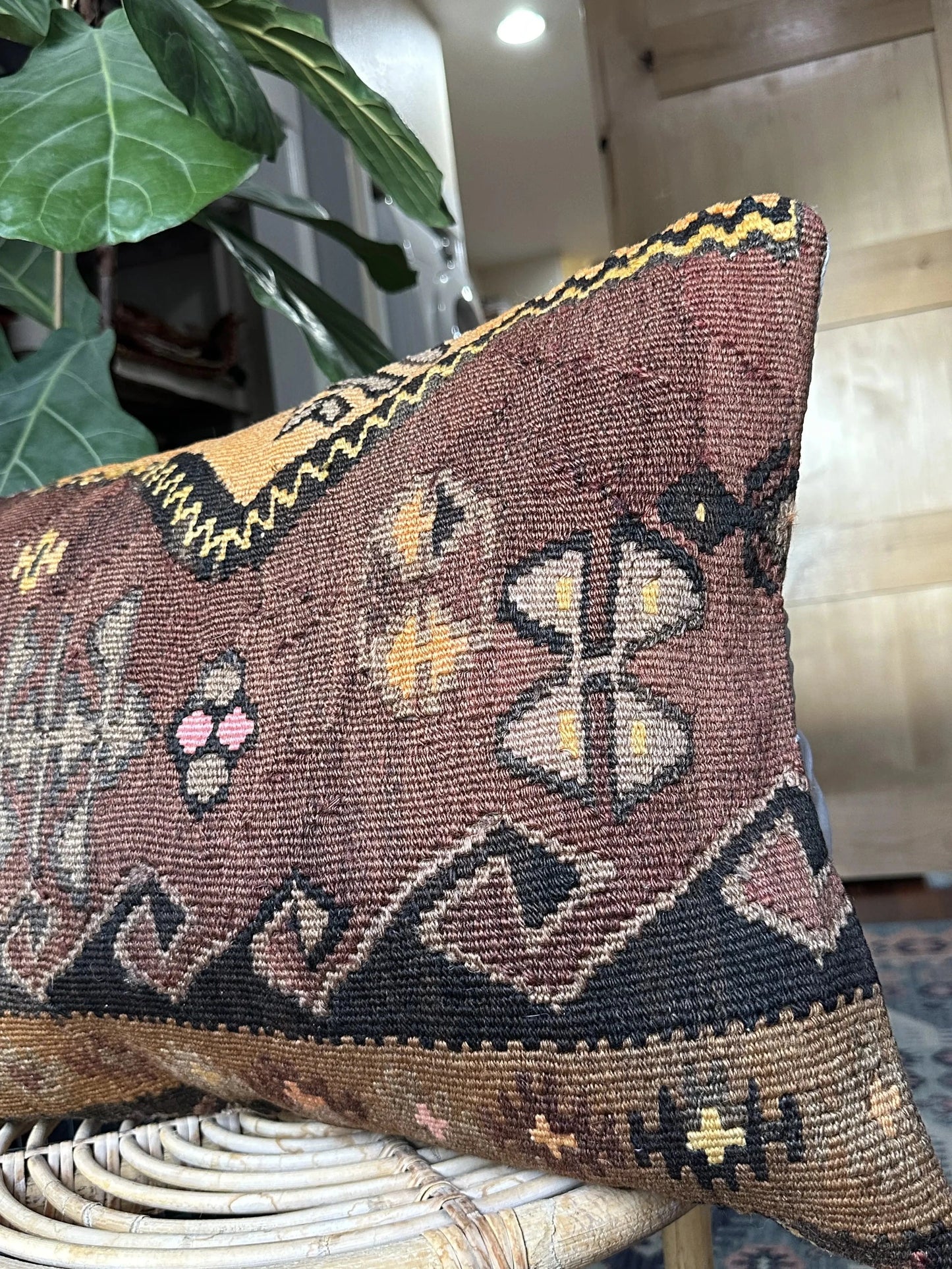 16 by 24 Turkish lumbar pillow featuring a muted color palette of browns and purples and accent colors of orange and yellow with geometric patterns throughout upcycled from a Turkish rug
