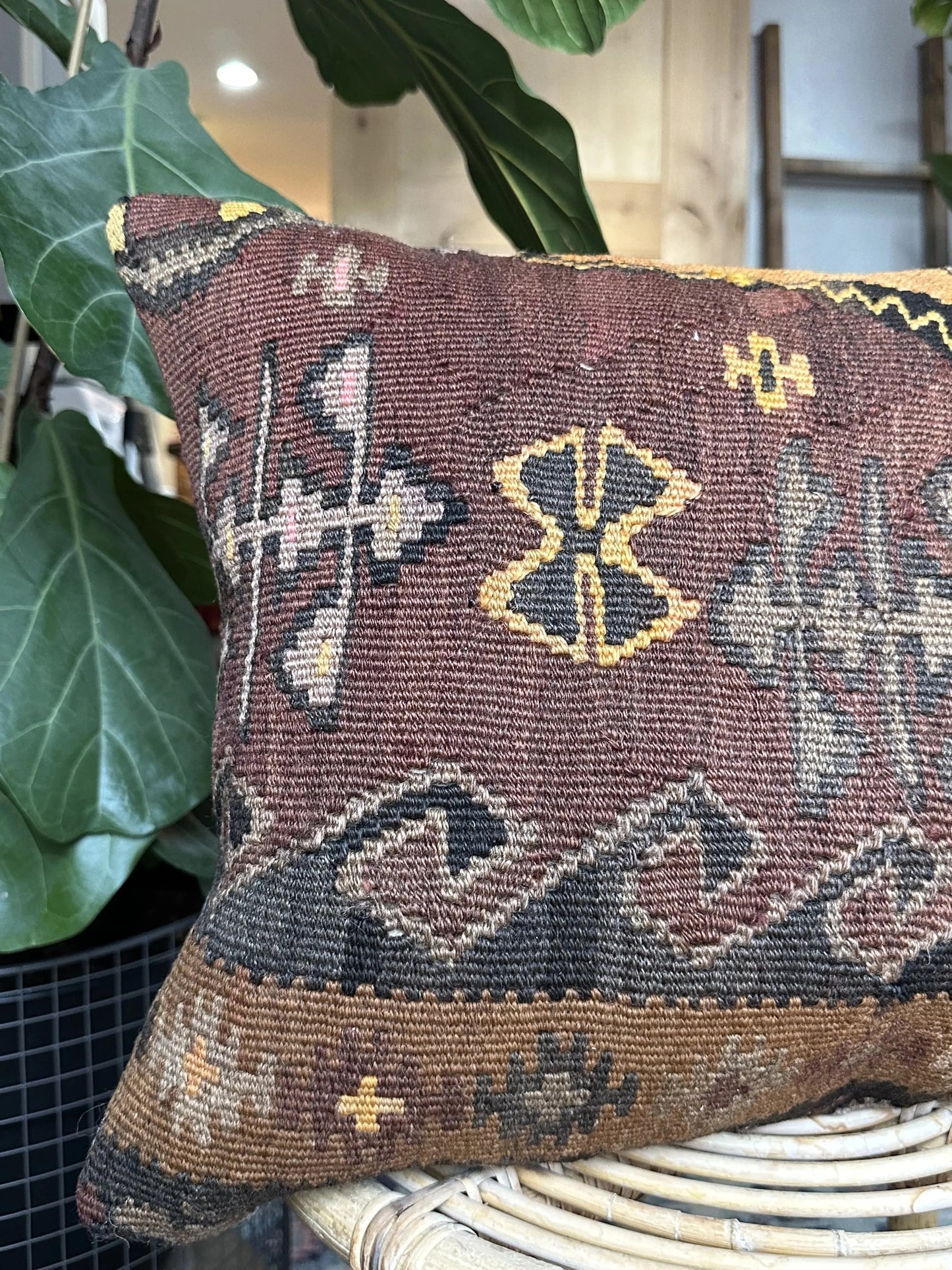 16 by 24 Turkish lumbar pillow featuring a muted color palette of browns and purples and accent colors of orange and yellow with geometric patterns throughout upcycled from a Turkish rug