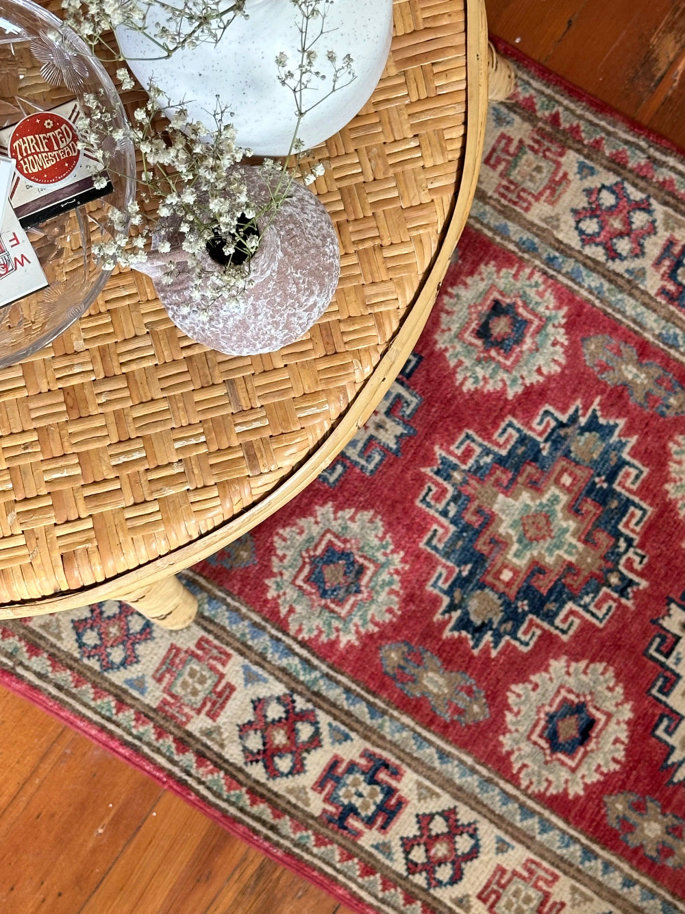 Hand-knotted 2x3 foot mini pile rug featuring a colorful geometric design, large central motif and geometric border - wool material with pops of red, light blue, navy and white.