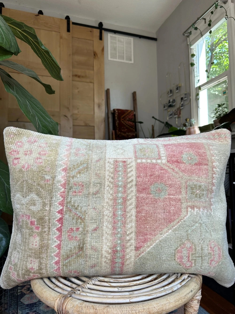 16 by 24 neutral Turkish Lumbar pillow featuring pops of pink and geometric floral pattern throughout