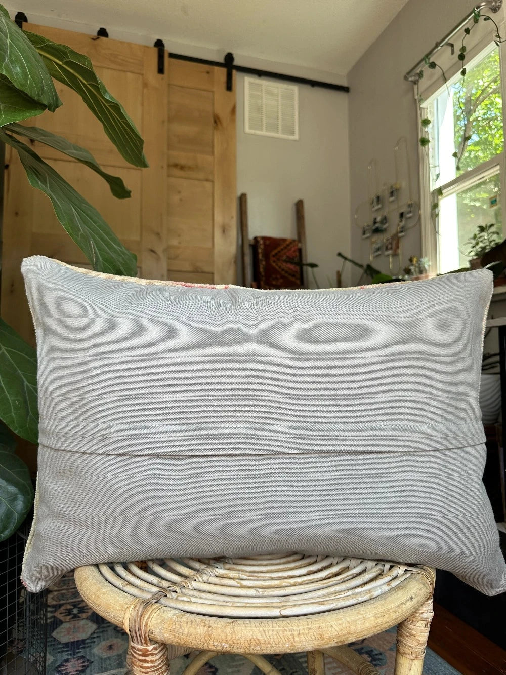 16 by 24 neutral Turkish Lumbar pillow featuring pops of pink and geometric floral pattern throughout