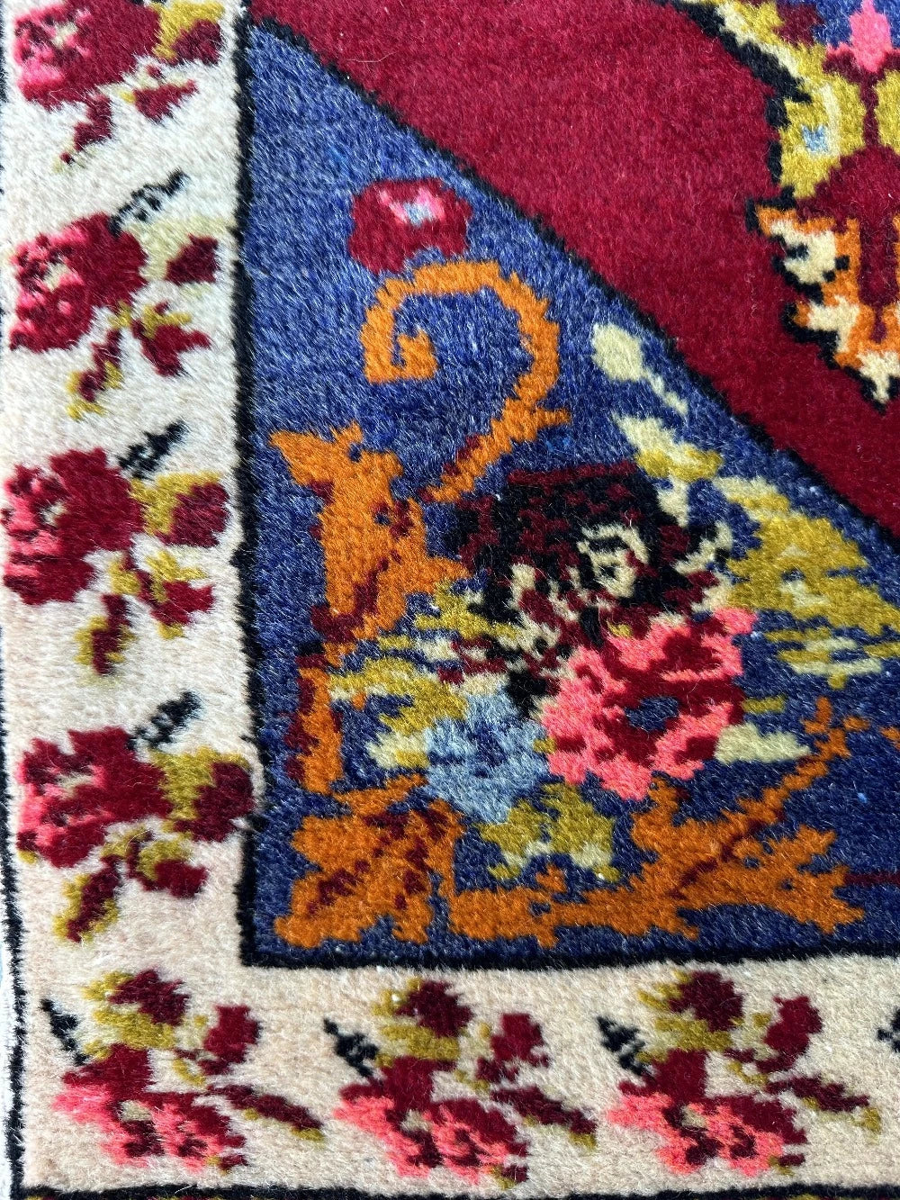 2 x 4 small floral Turkish area rug featuring rose and other floral patterns and deep red hues with bright pops of orange pink blue and green.