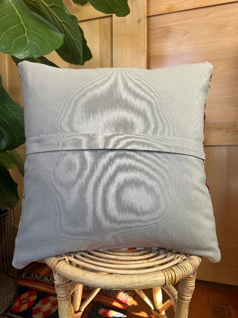Sustainably made kilim pillow from upcycled Turkish wool rugs. Handwoven by artisans, featuring bold tribal patterns in rust, gray, olive, and cream tones.