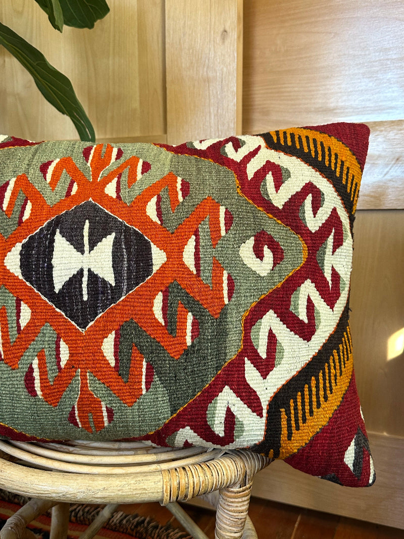 16 by 24 Decorative pillow with geometric pattern on a wooden stool indoors