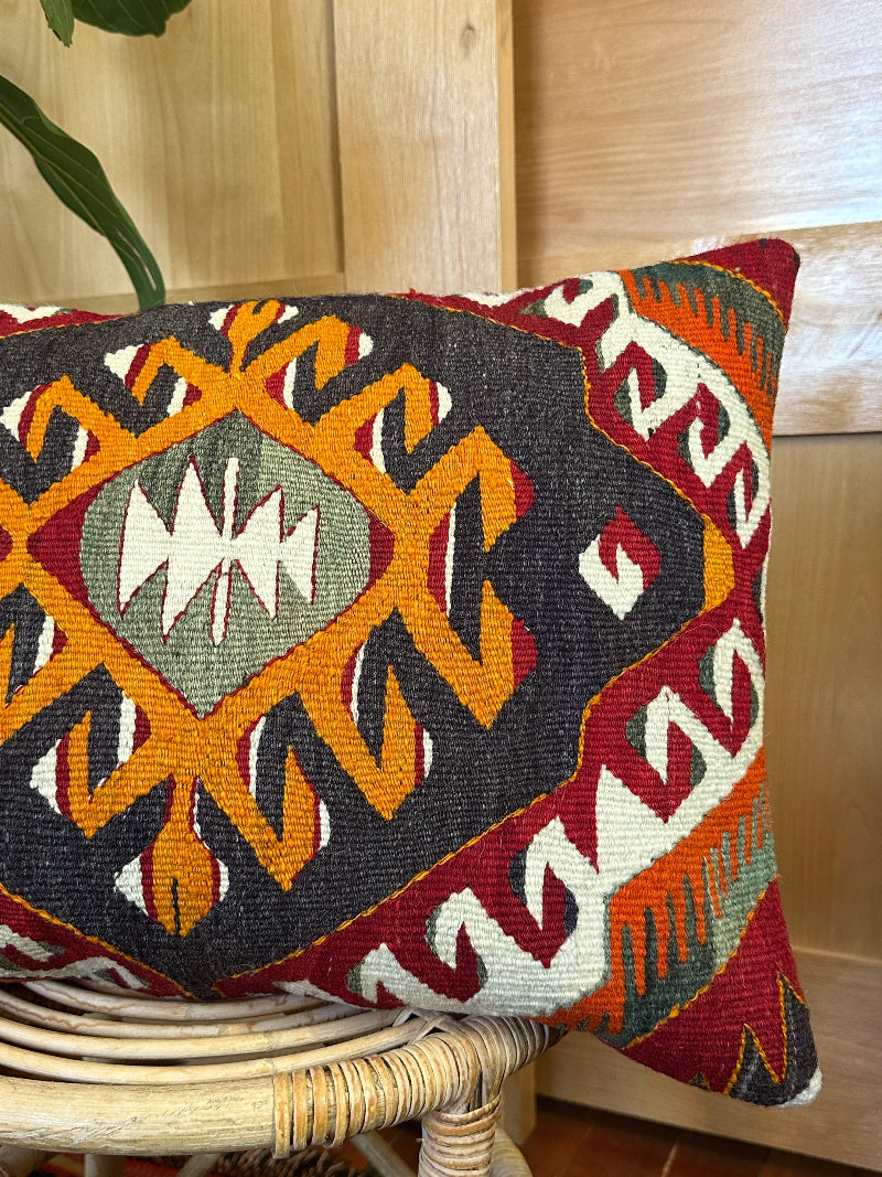 Decorative pillow with geometric pattern on a wicker chair