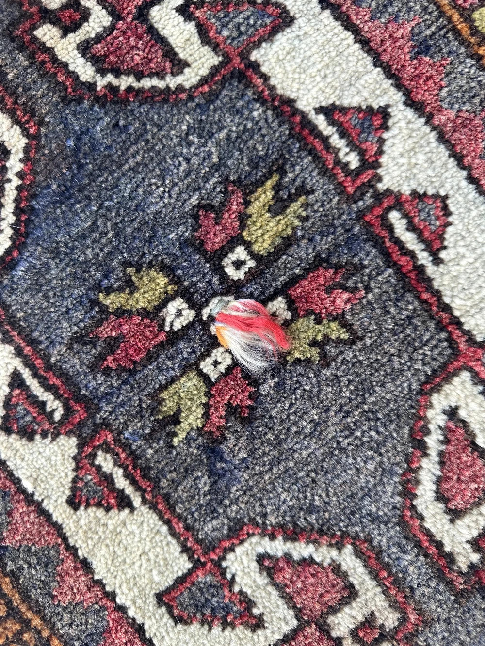 colorful mini turkish rug featuring pops of orange, green, navy and mauve and geometric patterns throughout