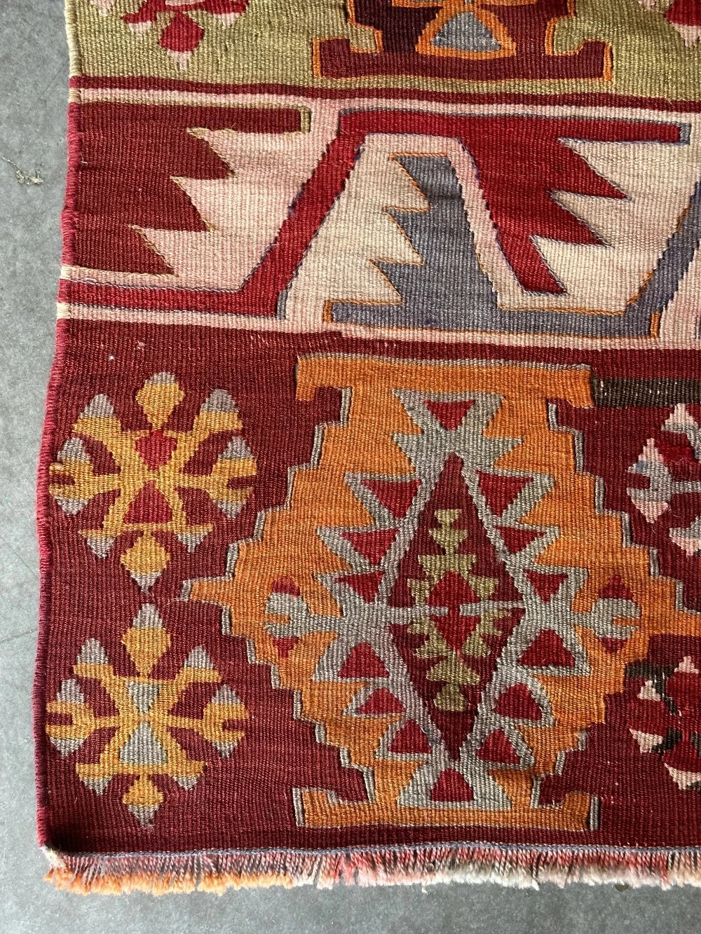 6 by 2.5 small colorful Turkish kilim runner featuring multicolored stripes around 12 inches wide and many different geometric patterns throughout