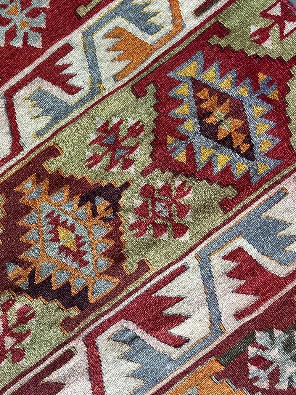 6 by 2.5 small colorful Turkish kilim runner featuring multicolored stripes around 12 inches wide and many different geometric patterns throughout