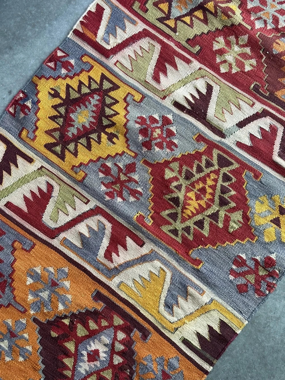 6 by 2.5 small colorful Turkish kilim runner featuring multicolored stripes around 12 inches wide and many different geometric patterns throughout