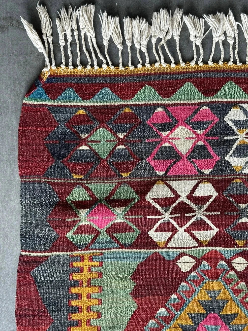 5.5 by 2.9 foot colorful Turkish area rug featuring diamond geometric patterns and bright accent colors
