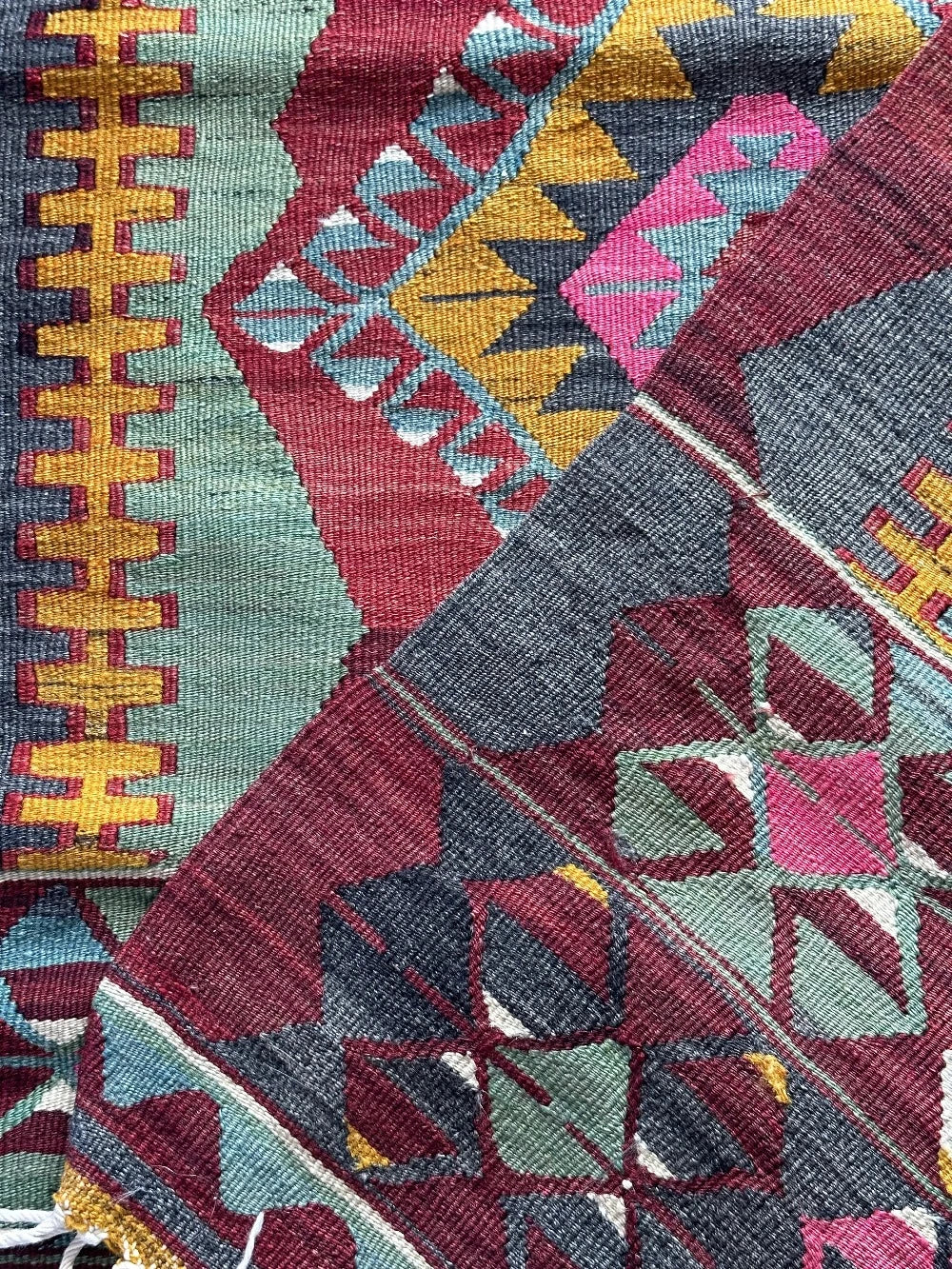 5.5 by 2.9 foot colorful Turkish area rug featuring diamond geometric patterns and bright accent colors