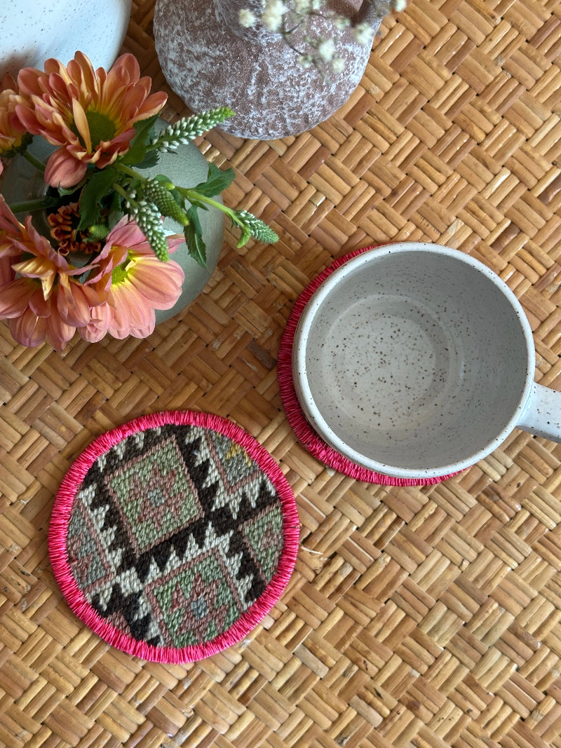 Handmade Turkish rug coasters with pink trim, repurposed from vintage rugs for a unique, sustainable home decor accent