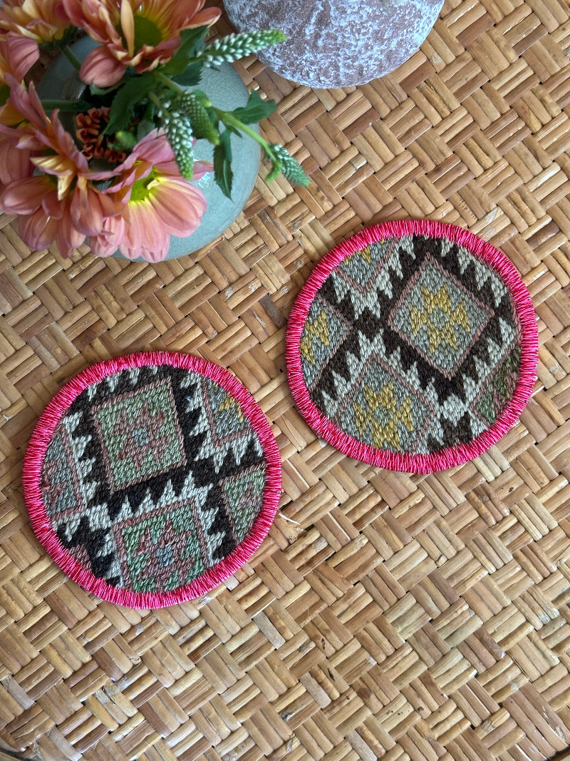 Handmade Turkish rug coasters with pink trim, repurposed from vintage rugs for a unique, sustainable home decor accent