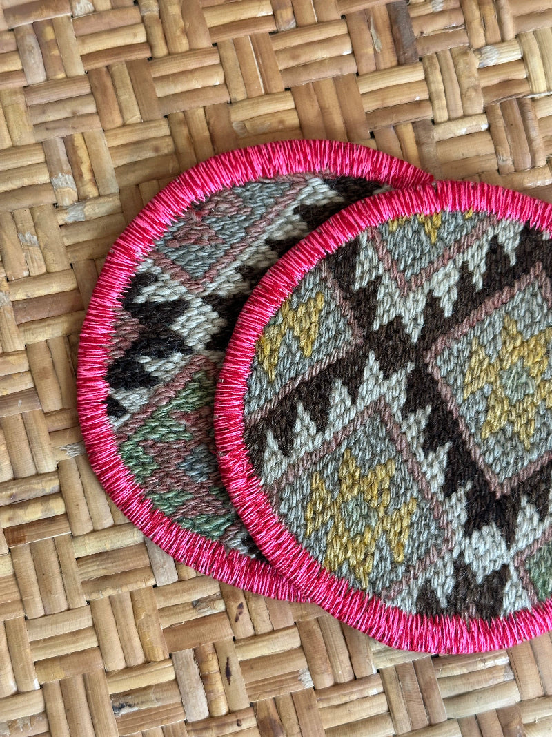 Handmade Turkish rug coasters with pink trim, repurposed from vintage rugs for a unique, sustainable home decor accent