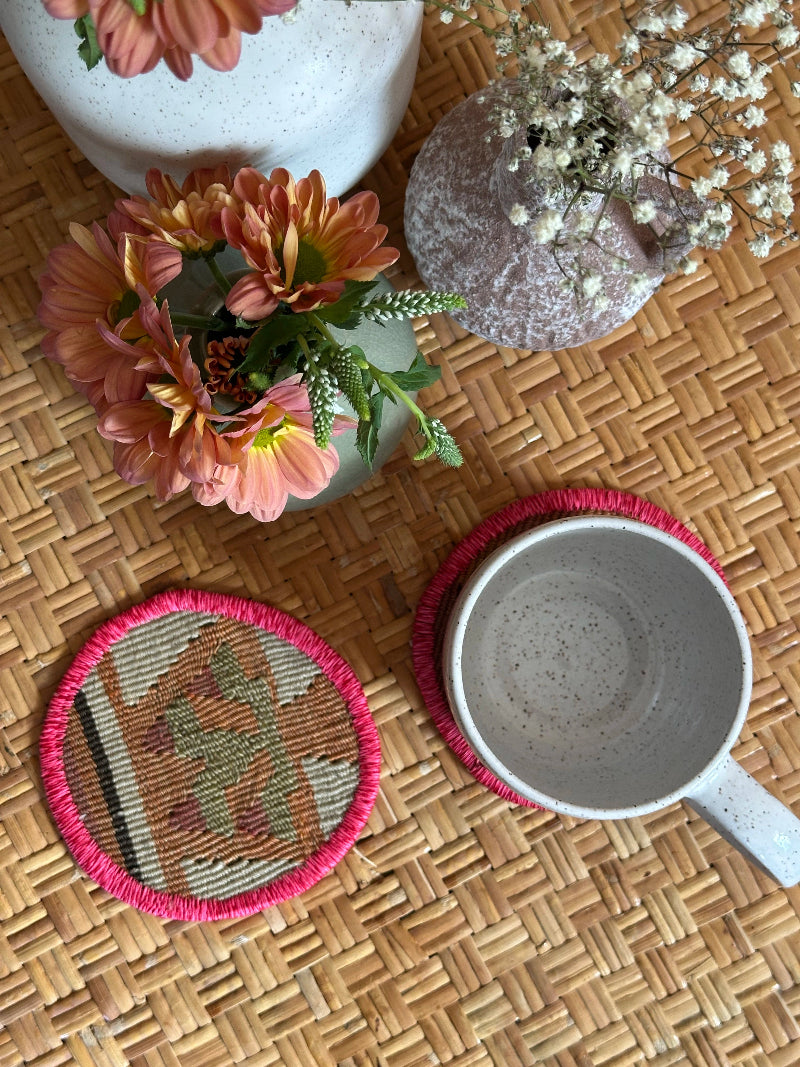 Handmade Turkish rug coasters with pink trim, repurposed from vintage rugs for a unique, sustainable home decor accent