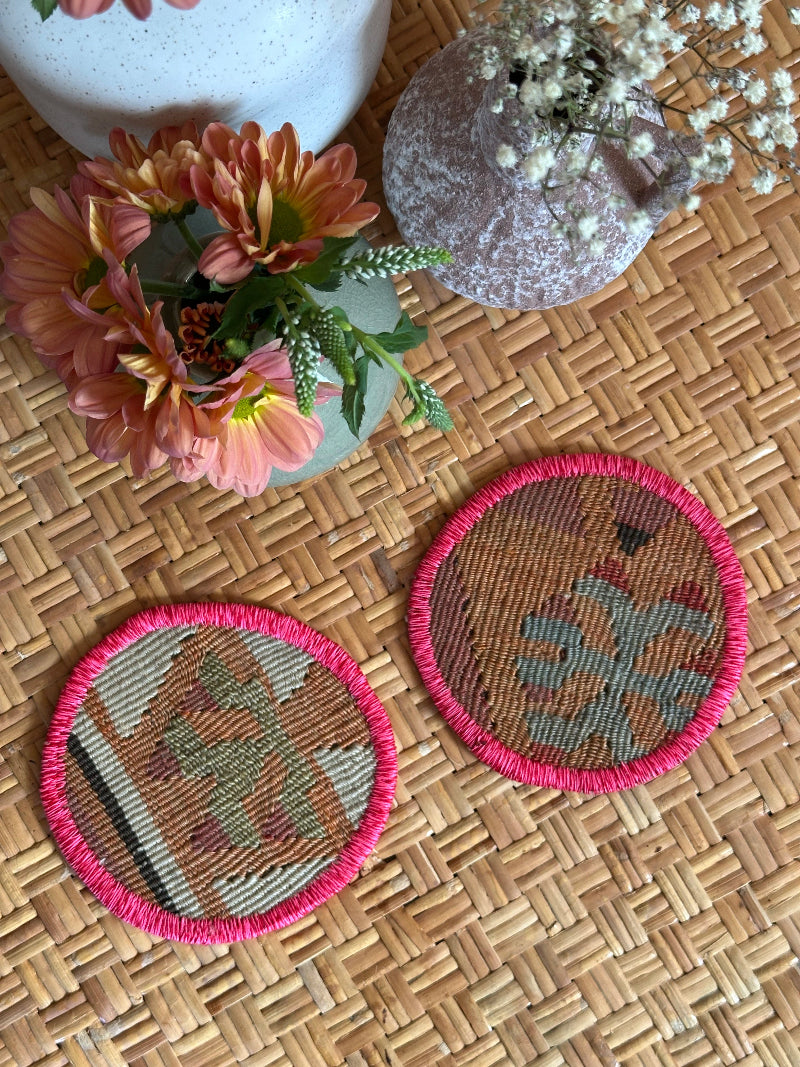 Handmade Turkish rug coasters with pink trim, repurposed from vintage rugs for a unique, sustainable home decor accent
