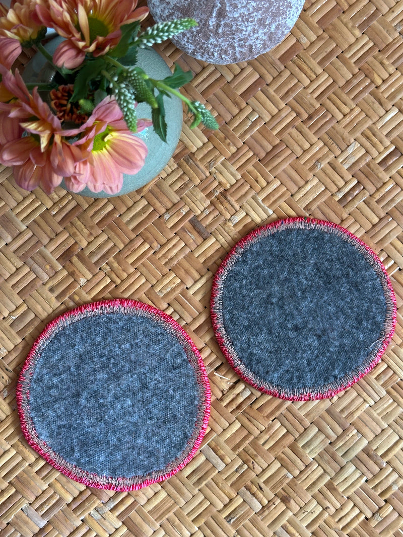 Handmade Turkish rug coasters with pink trim, repurposed from vintage rugs for a unique, sustainable home decor accent