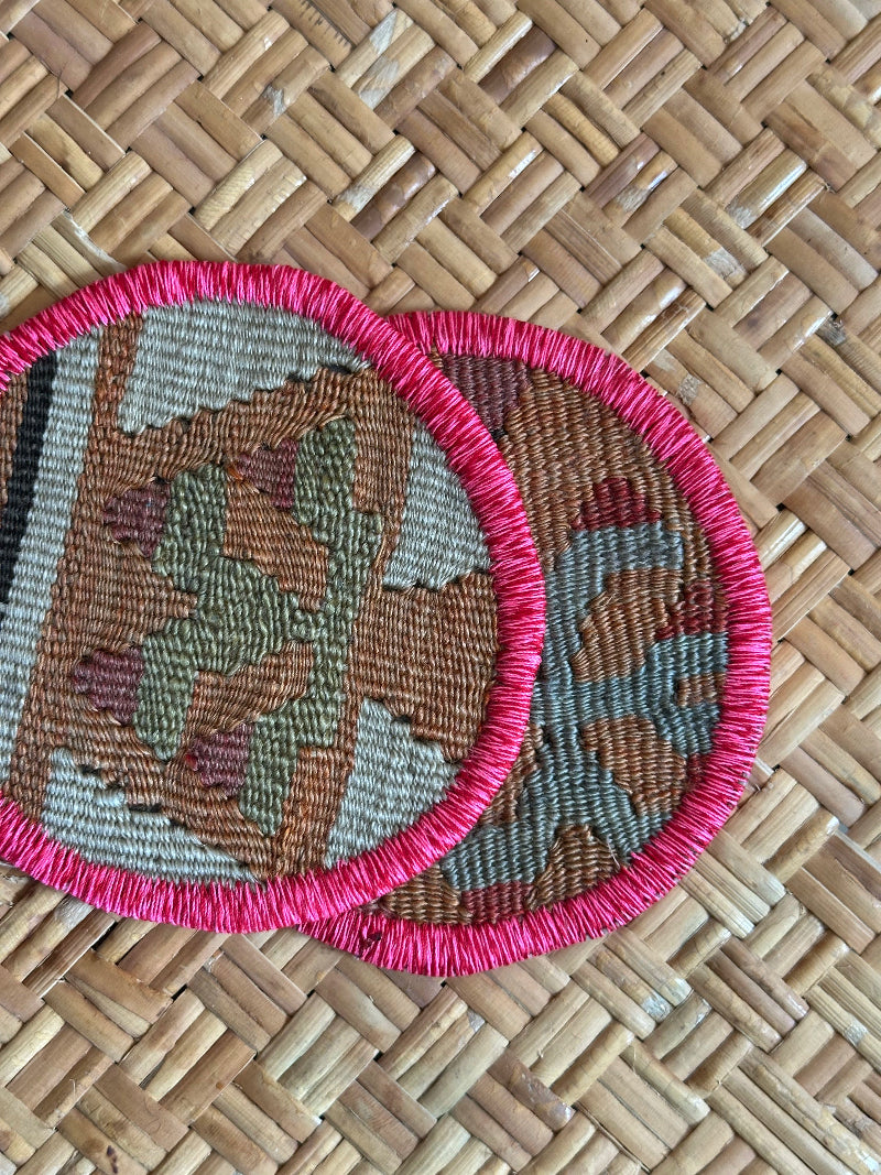 Handmade Turkish rug coasters with pink trim, repurposed from vintage rugs for a unique, sustainable home decor accent