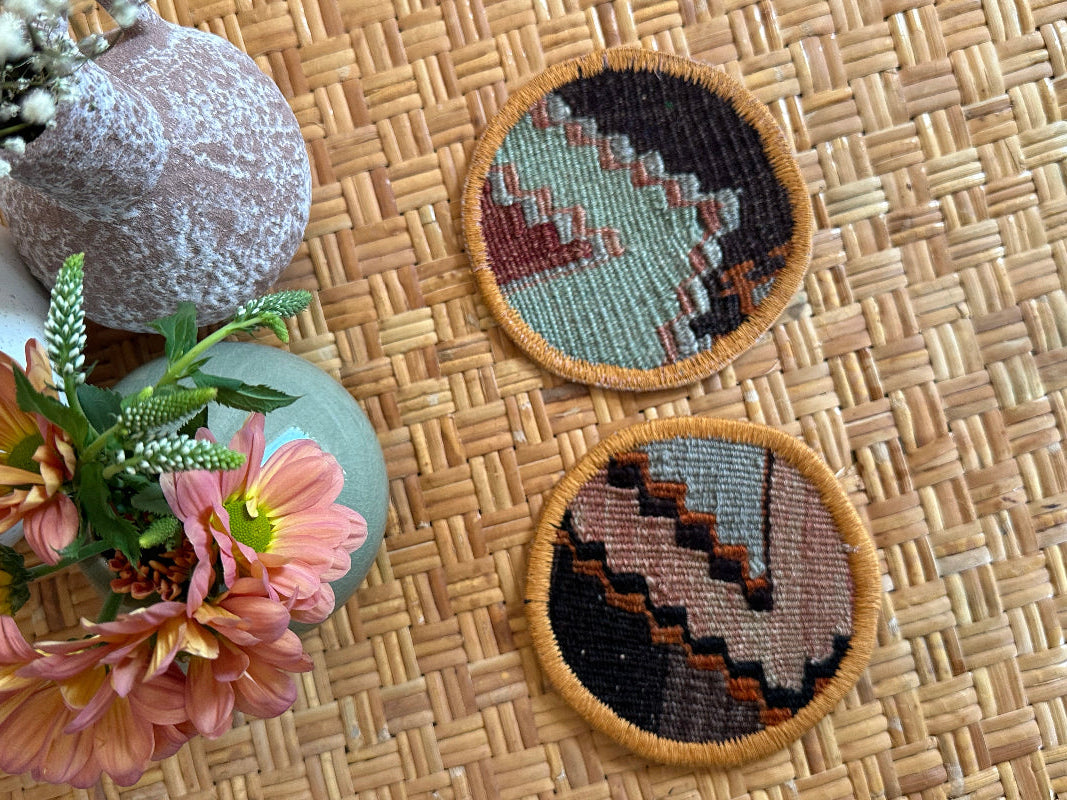 Handmade Turkish rug coasters with orange trim, repurposed from vintage rugs for a unique, sustainable home decor accent