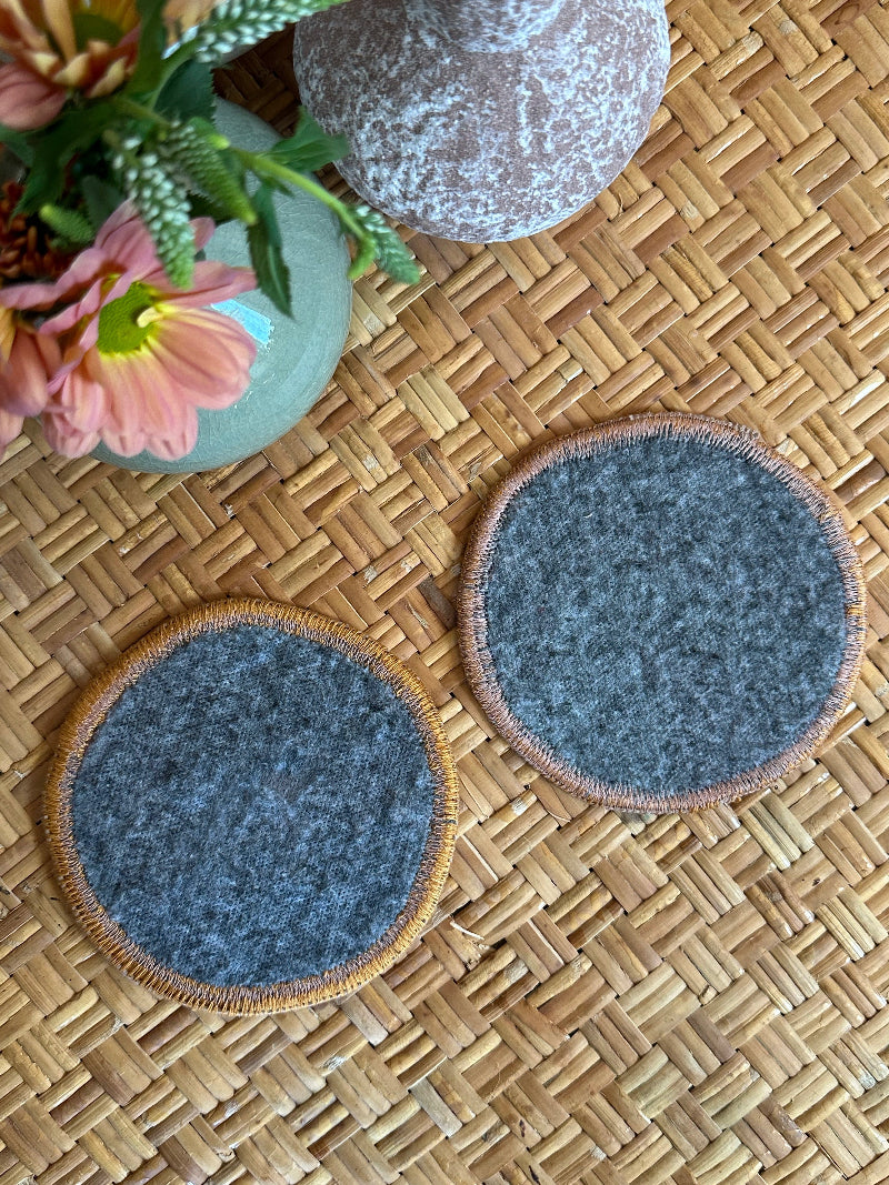 Handmade Turkish rug coasters with orange trim, repurposed from vintage rugs for a unique, sustainable home decor accent
