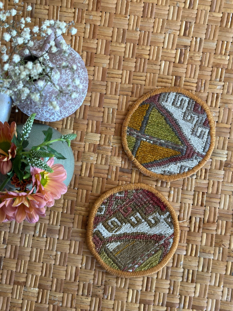 Handmade Turkish rug coasters with orange trim, repurposed from vintage rugs for a unique, sustainable home decor accent