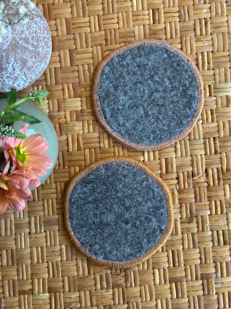 Handmade Turkish rug coasters with orange trim, repurposed from vintage rugs for a unique, sustainable home decor accent