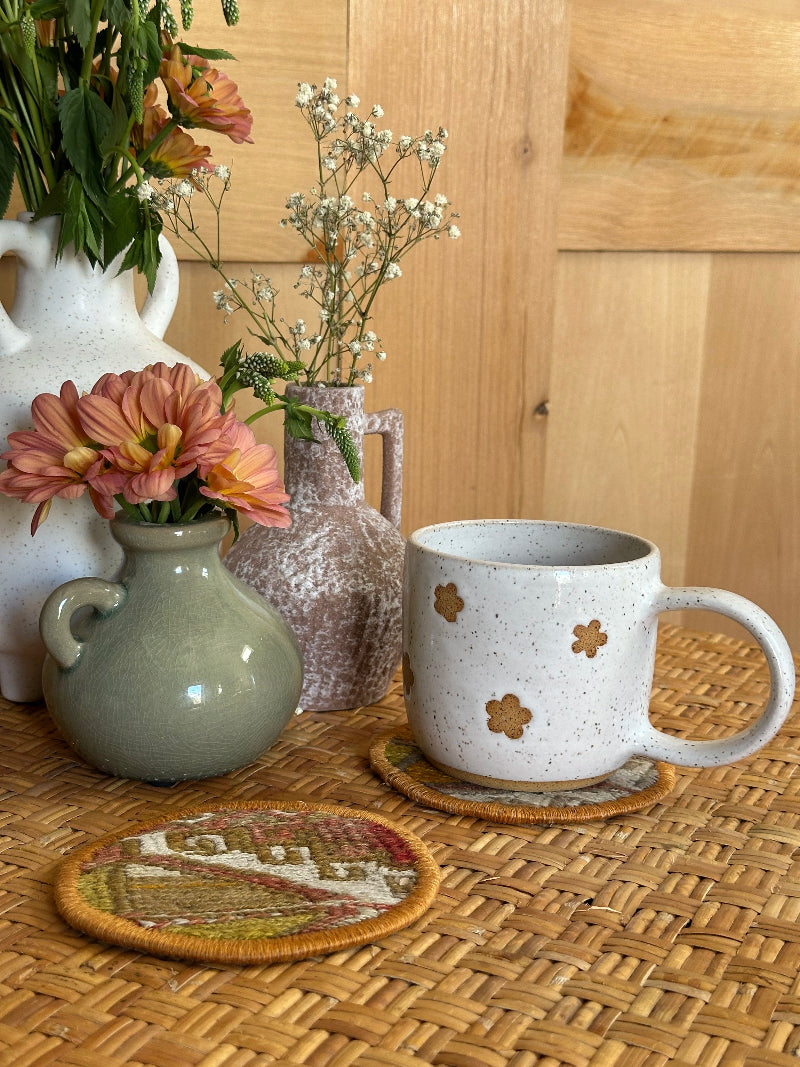 Handmade Turkish rug coasters with orange trim, repurposed from vintage rugs for a unique, sustainable home decor accent