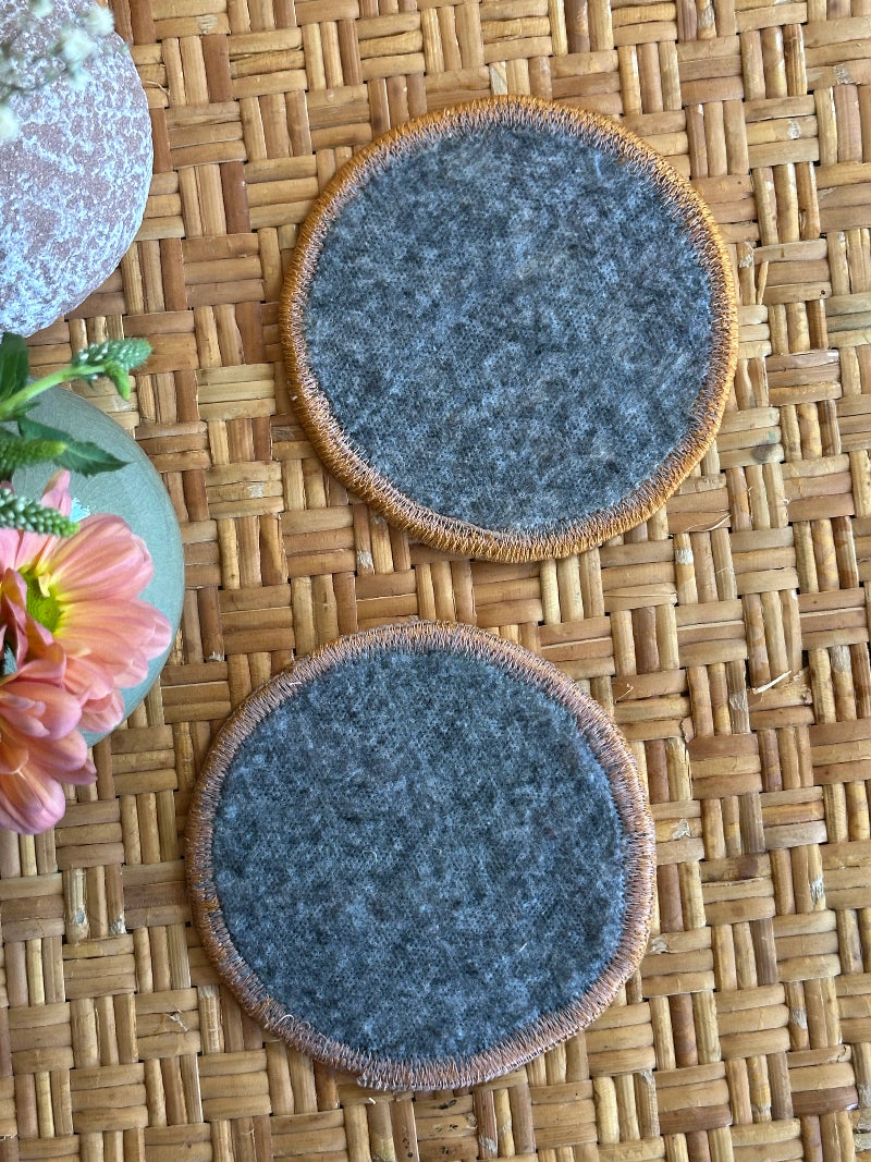 Handmade Turkish rug coasters with orange trim, repurposed from vintage rugs for a unique, sustainable home decor accent