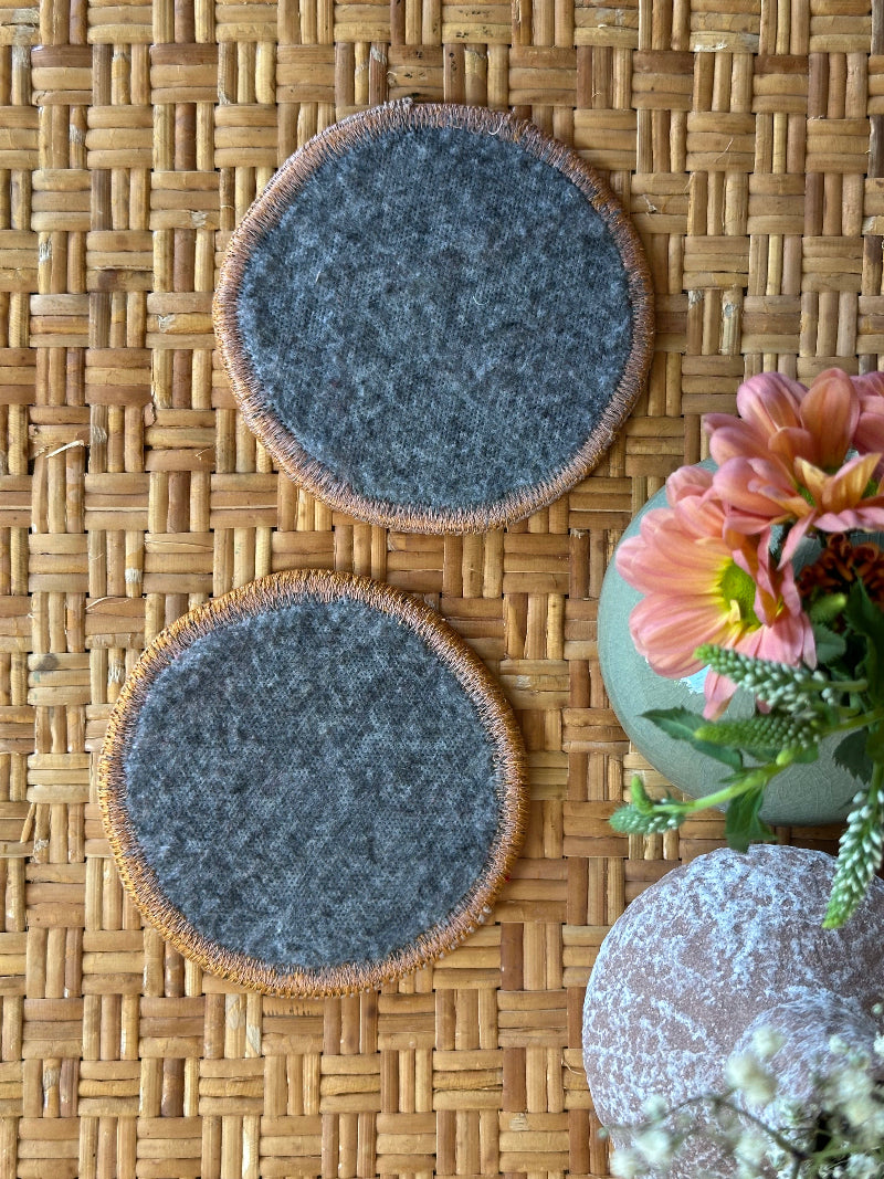 Handmade Turkish rug coasters with orange trim, repurposed from vintage rugs for a unique, sustainable home decor accent