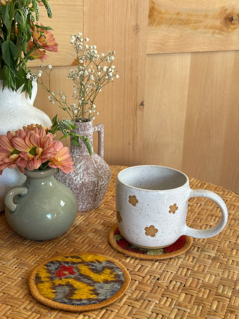 Handmade Turkish rug coasters with orange trim, repurposed from vintage rugs for a unique, sustainable home decor accent