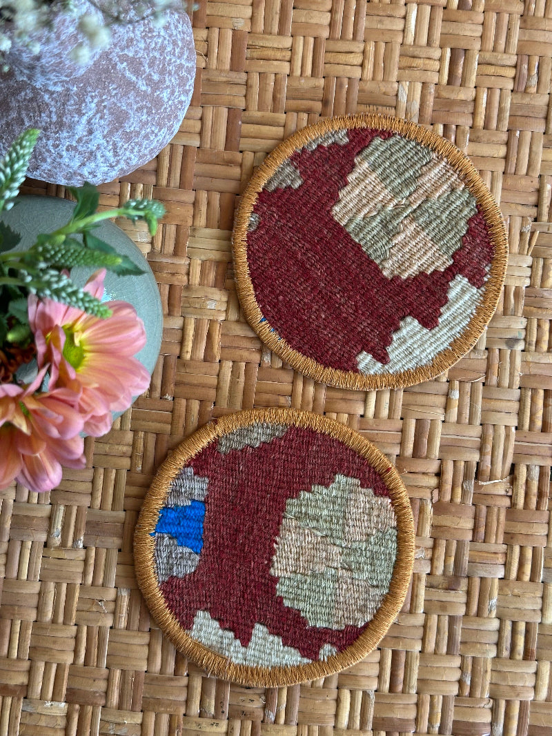 Handmade Turkish rug coasters with orange trim, repurposed from vintage rugs for a unique, sustainable home decor accent