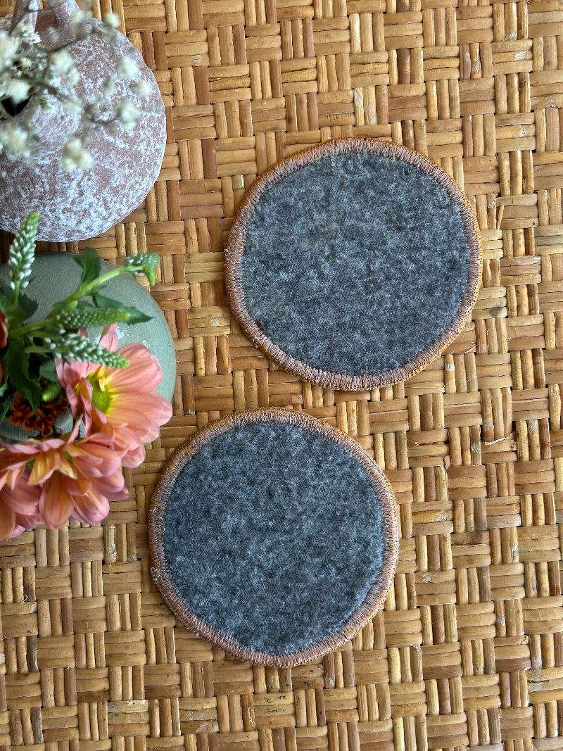 Handmade Turkish rug coasters with orange trim, repurposed from vintage rugs for a unique, sustainable home decor accent