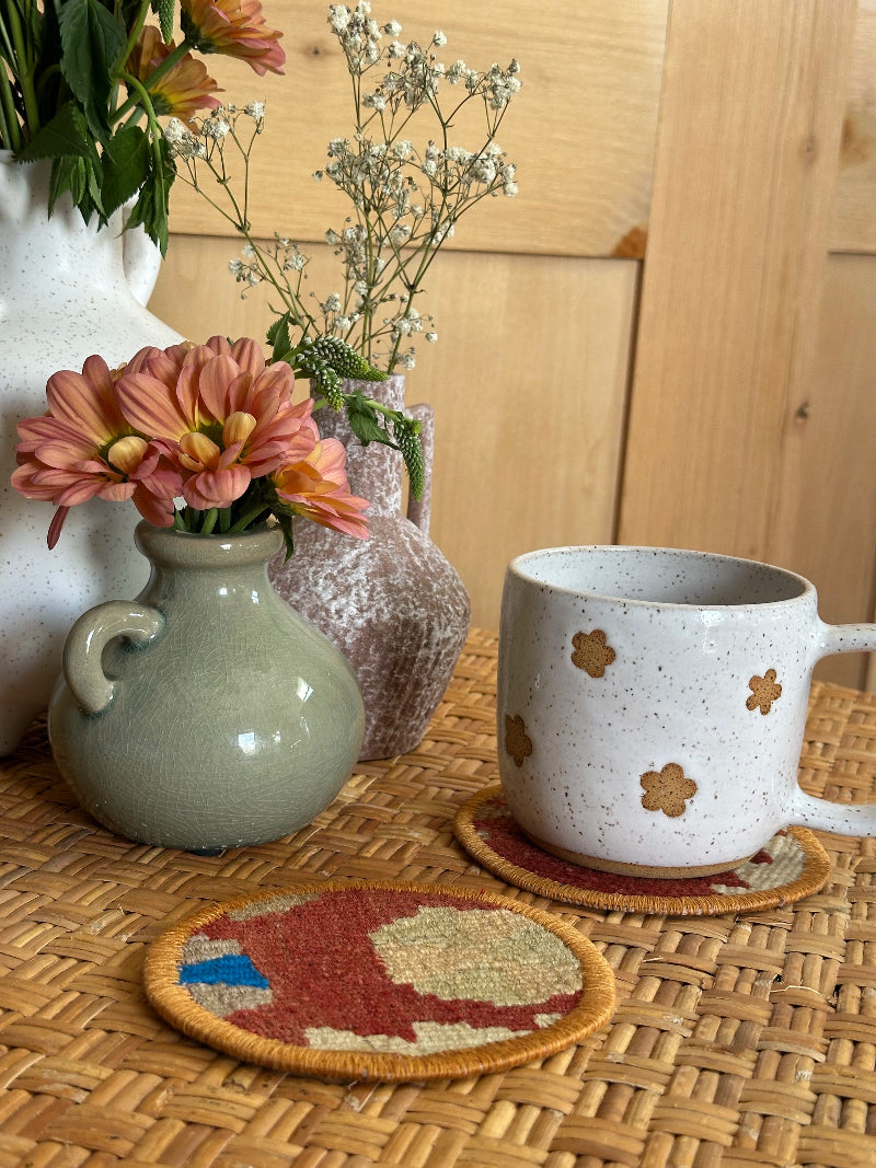 Handmade Turkish rug coasters with orange trim, repurposed from vintage rugs for a unique, sustainable home decor accent