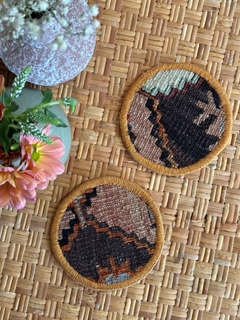 Handmade Turkish rug coasters with orange trim, repurposed from vintage rugs for a unique, sustainable home decor accent
