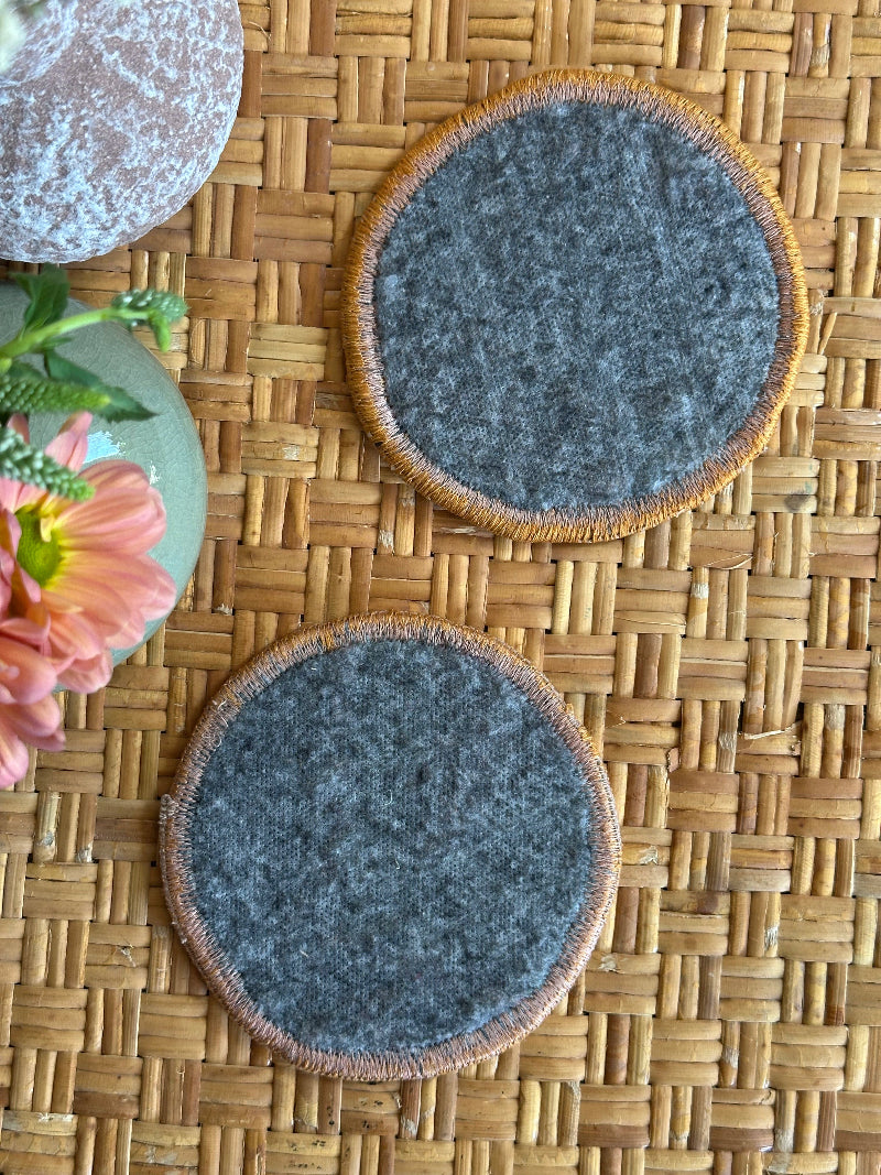 Handmade Turkish rug coasters with orange trim, repurposed from vintage rugs for a unique, sustainable home decor accent