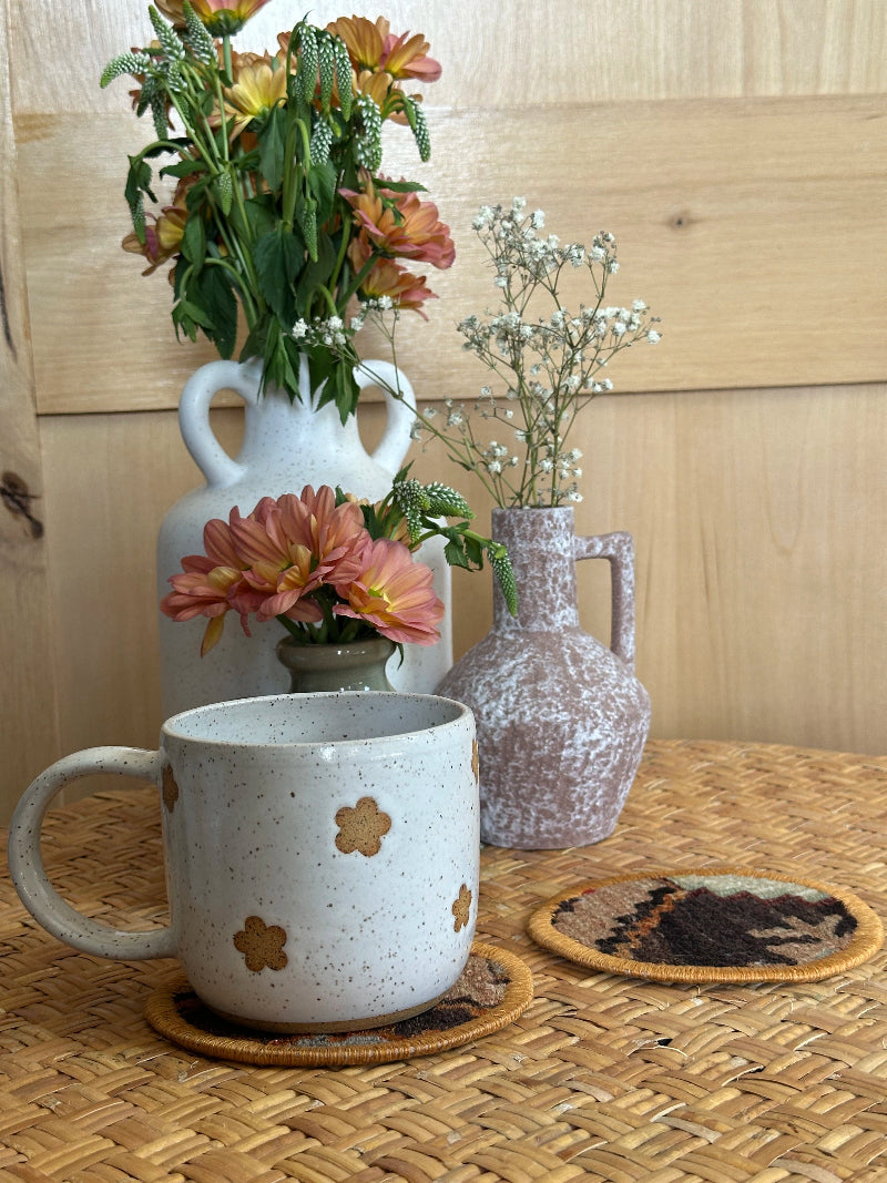Handmade Turkish rug coasters with orange trim, repurposed from vintage rugs for a unique, sustainable home decor accent