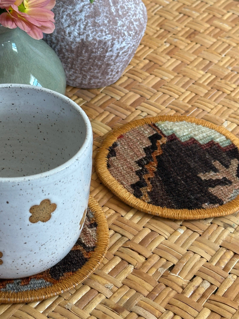 Handmade Turkish rug coasters with orange trim, repurposed from vintage rugs for a unique, sustainable home decor accent